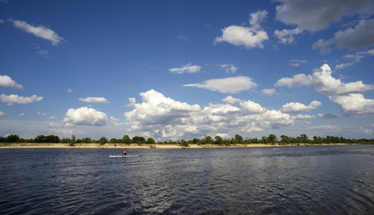 Summer landscape with river and clouds in the sky.