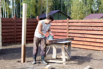 man cut wooden beam with circular saw