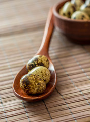 Quail eggs in wooden spoon