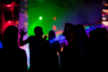 Fototapeta na wymiar Silhouettes of people dancing in nightclub at a party