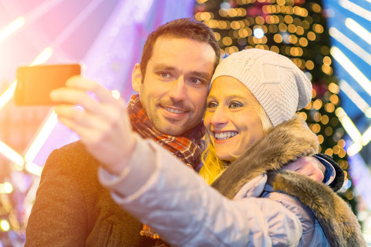 Young attractive couple in a christmas market taking selfie