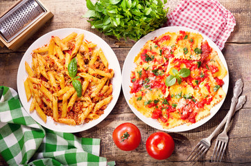 plates of italian food. Pasta bolognese and ravioli with tomato