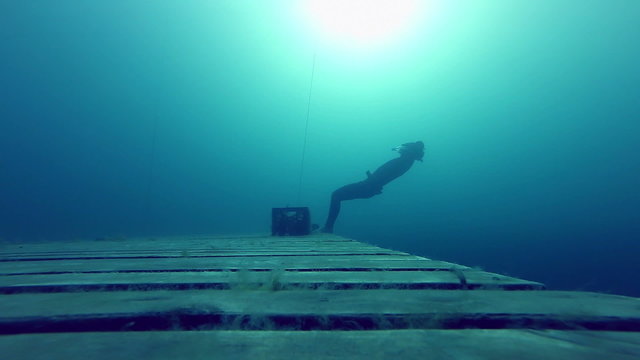 Freediver Experiencing a super Slow free fall Underwater Falling of a Platform into a Quarry.