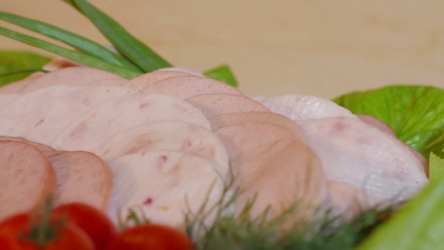 CLose upt sliced sausages, tomatoes in white plate