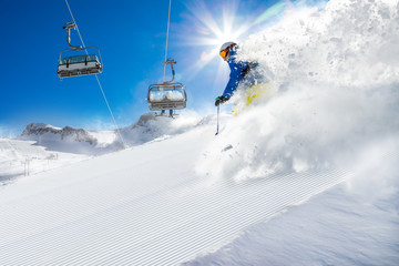 Skier skiing downhill in high mountains