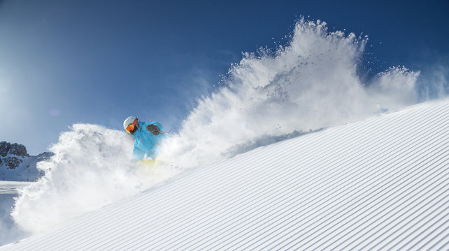Skier skiing downhill in high mountains