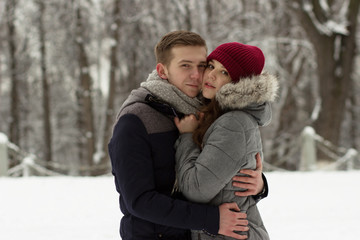 Obraz premium Hugging pair standing in winter park