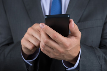 Close up of business man hands holding mobile phone