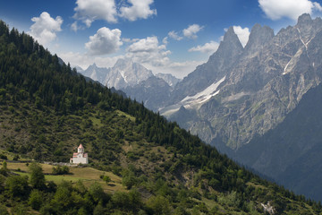 Fototapeta na wymiar Caucasus mountines with wiew to small church near Mestia direct to Chalati galcier