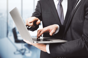 Business partners working with laptop in empty office