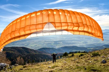 Fototapete Luftsport Paraglider is starting off a mountain