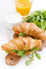 fresh croissant stuffed with fish and arugula for breakfast