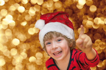 Close-up of a cute little boy with Santa smiling and pointing on