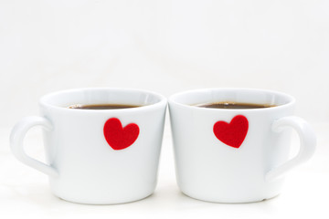 White coffee cups with red hearts, closeup