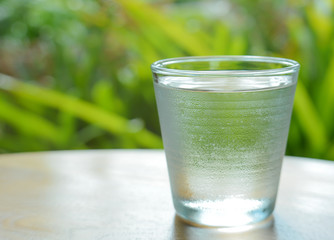 Glass water,Ice glass on green background.