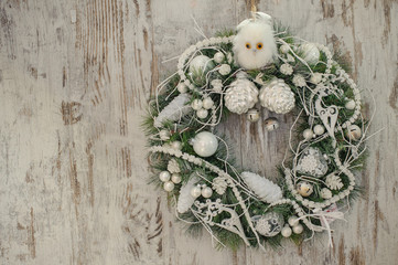 Christmas wreath with whiye decor   on old wooden background.