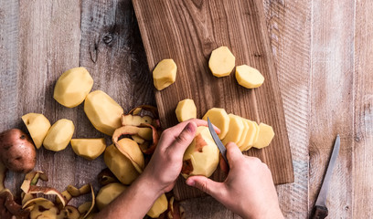 hands peeling potato