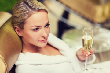 beautiful young woman drinking champagne at spa