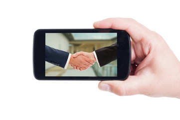 Business people handshake picture on smartphone display