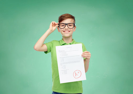 Happy Boy In Eyeglasses Holding School Test Result