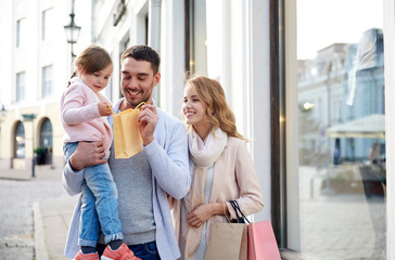happy family with child and shopping bags in city