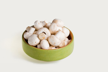 White mushrooms in a green bowl