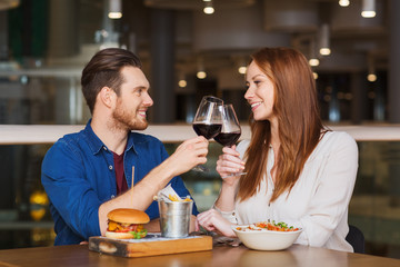 happy couple dining and drink wine at restaurant