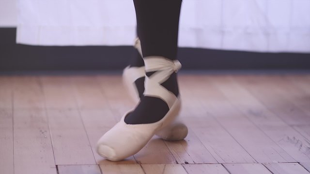 Close up of a ballet dancer's feet as she jumps and changes positions