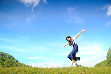happy girl stretch the arms on blue sky