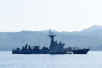 Obraz premium Big warship on a background of a hill