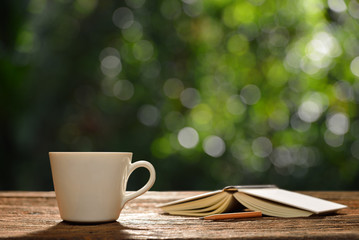 Cup of coffee and book in the garden