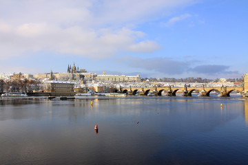 Obraz premium Christmas snowy Prague Lesser Town with gothic Castle and Charles Bridge, Czech Republic