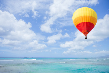 Fototapeta na wymiar Colorful hot air balloon over blue sea