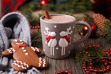 Cup of hot chocolate or cocoa with two cute deer, cinnamon and gingerbread man cookie in new year...