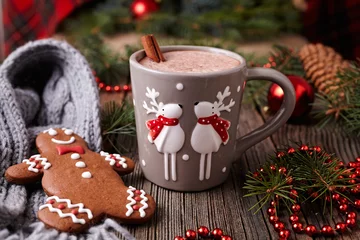 Foto op Canvas Cup of hot chocolate or cocoa with two cute deer, cinnamon and gingerbread man cookie in new year tree decorations frame on vintage wooden table background. Homemade traditional celebration recipe © GreenArt Photography