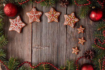 Gingerbread star cookies christmas composition in new year tree decorations frame on vintage wooden table background. Empty space for designer text. Top view. Traditional homemade holiday recipe