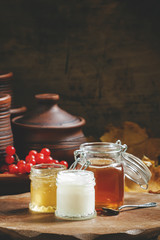 Honey assortment in small jars in the autumn background with row