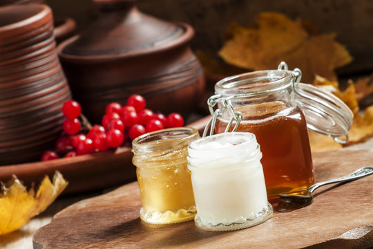 Honey assortment in small jars in the autumn background with row
