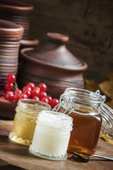 Honey assortment in small jars in the autumn background with row
