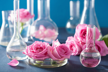 alchemy and aromatherapy with rose flowers and chemical flasks