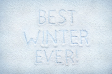 Text BEST WINTER EVER written on snow. Horizontal postcard.