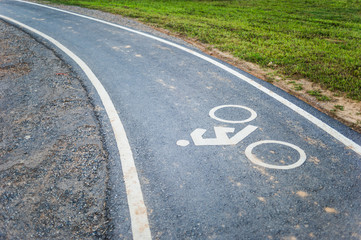 Obraz premium Znak rowerowy na ścieżce rowerowej, w ogrodzie