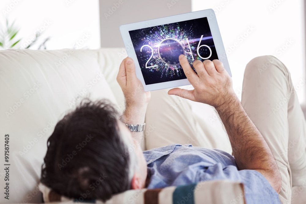 Poster composite image of man laying on sofa using a tablet pc
