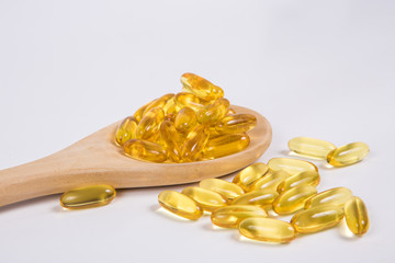 Omega 3 fish oil capsule on wooden spoon