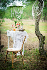 Ancient chair against wedding decoration in style of a shabby chic. Decoration of a wedding photoshoot.  Details of a wedding decor.