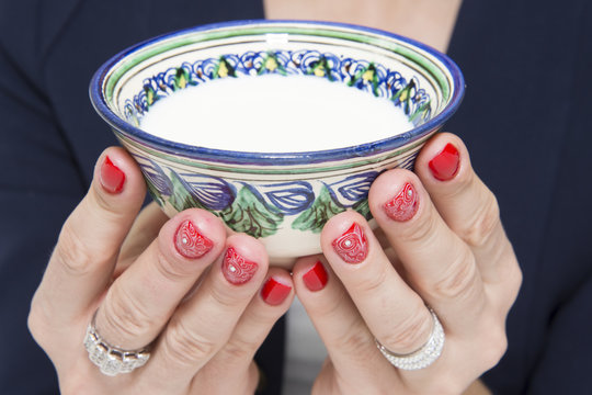 Red nail art design with a white pattern and small piala with kumis (mare's milk).
