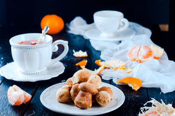 teacup with tea and biscuits on a black table