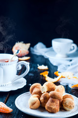 teacup with tea and biscuits on a black table