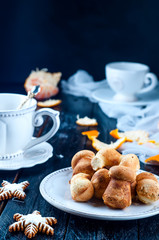 teacup with tea and biscuits on a black table