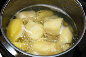 Potatoes boiling in saucepan